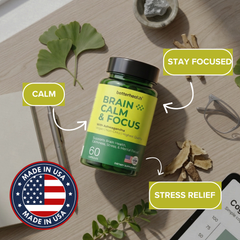 Bottle of 'Brain Calm & Focus' supplements on a wooden surface with leaves and a phone.